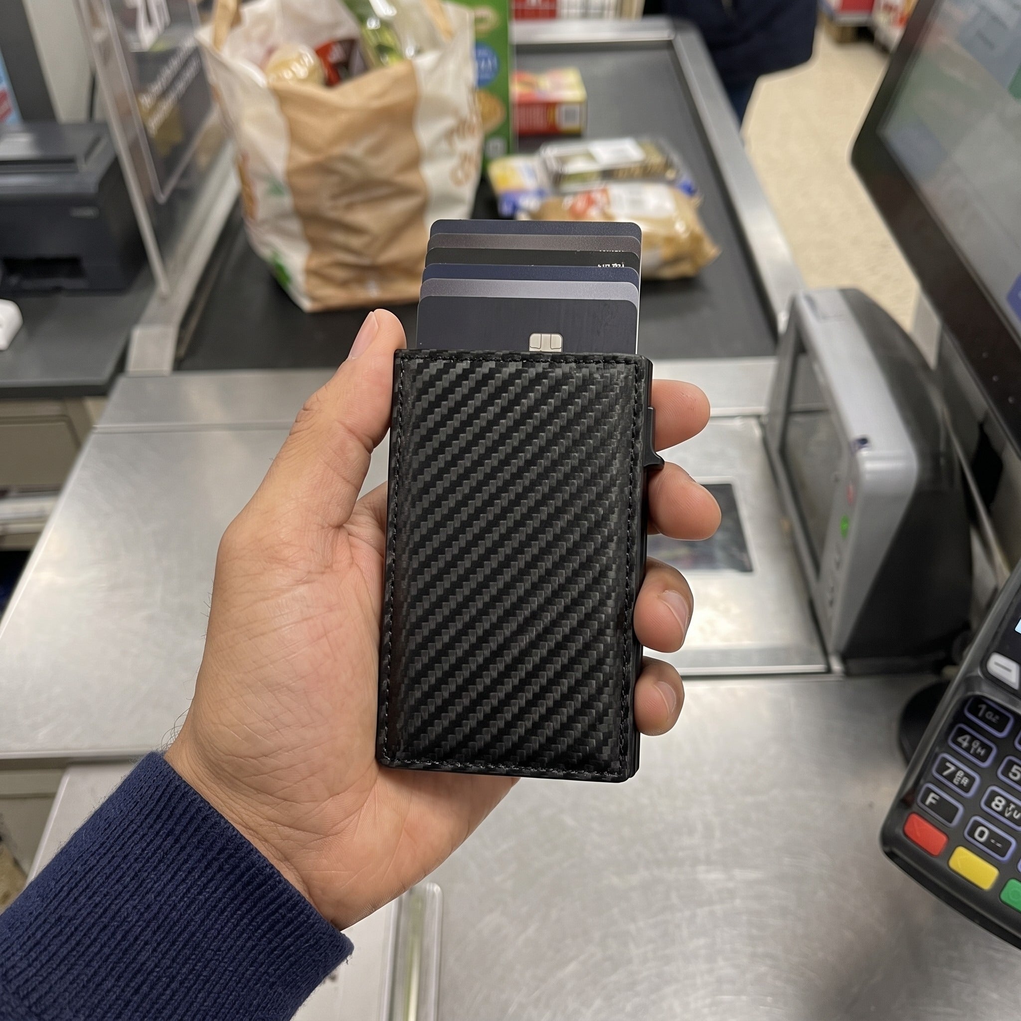 Daniel selecting a carbon wallet card at the grocery checkout